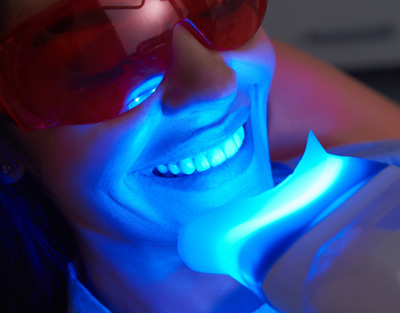 Woman in dental chair looking at her smile in mirror