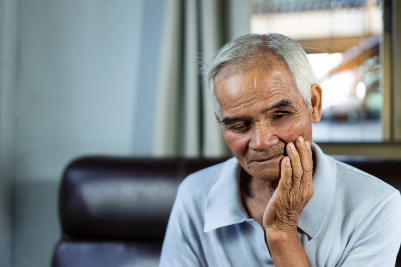 An older man dealing with a toothache